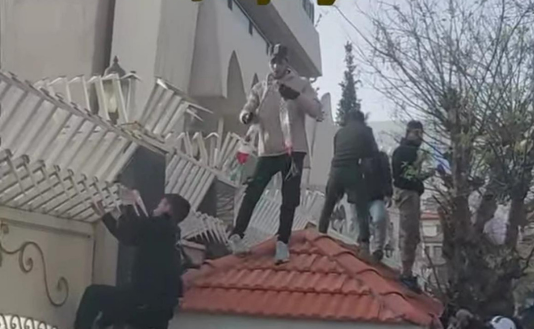 محتجون يقومون بإنزال العلم الإماراتي عن السفارة الإماراتية في دمشق